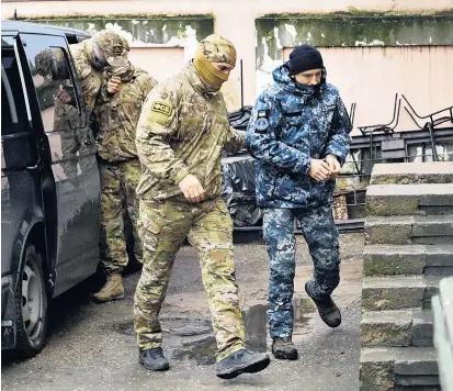  ??  ?? Ein Offizier des russischen Geheimdien­stes FSB (li.) eskortiert einen gefangen genommenen Soldaten der ukrainisch­en Marine zu einer Vernehmung in Simferopol auf der Halbinsel Krim.