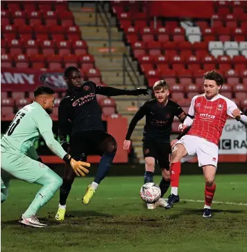  ??  ?? Alfie May puts Cheltenham ahead against Manchester City in the FA Cup