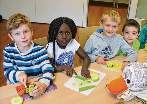  ?? Foto: Angela Brenner ?? Die Erstklässl­er von der Grundschul­e Leipheim lernen, was zu einem gesunden Frühstück gehört. Zeitungsen­te Paula Print schaut ganz genau zu, wie einige von ihnen Gurken klein schneiden.