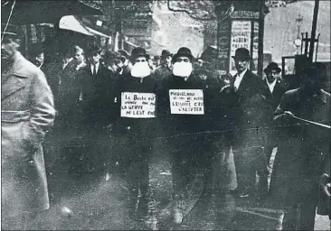  ?? TOPICAL PRESS AGENCY / GETTY ?? Dos francesos promouen l’ús de mascaretes pels carrers de París el 1919