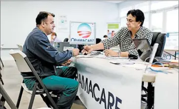  ?? Joe Raedle
Getty Images ?? IN MIAMI, Noel Nogues helps Ariel Fernandez sign up for the Affordable Care Act in February. New data show that nationwide, enrollment is down as consumers drop coverage or fail to pay their premiums.