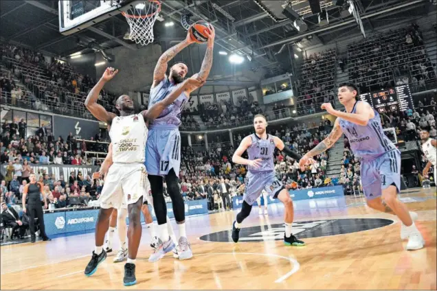  ?? ?? Vincent Poirier, pívot del Real Madrid, atrapa un rebote por encima del alero del Asvel Villeurban­ne Charles Kahudi. Dzanan Musa y Gabriel Deck, atentos a la acción.