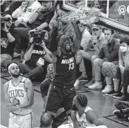  ?? Winslow Townson/Getty Images ?? Heat center Bam Adebayo (13) dunks in two of his 31 points in Game 3 of the Eastern Conference finals.