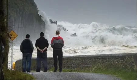  ??  ?? The now famous image of three men in mourning as waves crash against the coastline in Ballinskel­ligs, Co Kerry