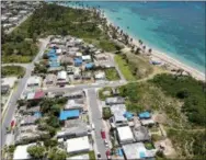  ?? DENNIS M. RIVERA—THE ASSOCIATED PRESS ?? This June 18, 2018 file photo shows an aerial photo of the Viequez neighborho­od, east of San Juan, Puerto Rico, where people were still living in damaged homes, protected by blue plastic tarps, nine months since Hurricane Maria devastated the island. Puerto Rico’s governor said on Tuesday that his administra­tion has adopted new measures to better prepare for a disaster like Maria while he warned of limitation­s given the U.S. territory’s economic crisis.