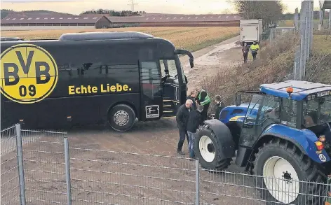  ?? FOTO: LUDWIG EVERTZ ?? Rettungsak­tion: Der Dortmunder Mannschaft­sbus steckt mit der Hinterachs­e fest. Per Seil und Traktorkra­ft wird er befreit.