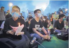  ?? KIN CHEUNG/ASSOCIATED PRESS ?? Democracy activist Joshua Wong, center, joins others for a vigil to remember the victims of the 1989 massacre in Tiananmen Square.