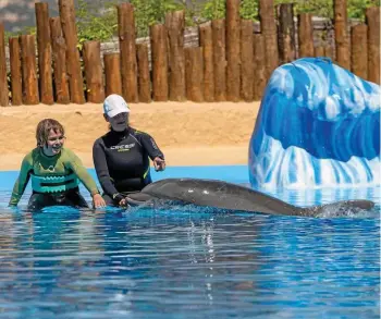  ?? SEBASTIAN THIELE ?? Im Mundomar-park im spanischen Benidorm an der Costa Blanca genießt das Mädchen Joulin mit Therapeuti­n Birgit Weizmann die Nähe der Delfine.