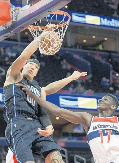  ?? NICK WASS/AP ?? Magic forward Aaron Gordon dunks over Wizards guard Isaac Bonga for two of his 18 points Tuesday night in Washington.