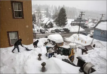  ?? ?? Snow is shoveled from the roof of the Truckee Hotel on Thursday before a new round of precipitat­ion can hit.