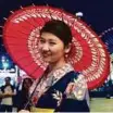  ?? Arshad Ali/Gulf News ?? A Japanese woman dressed in a traditiona­l Kimono invites visitors to get their names painted in Japanese Hiragana characters.