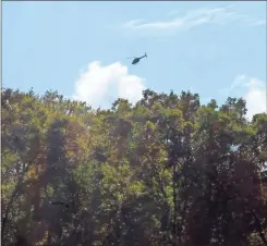  ?? Jeremy Stewart ?? A helicopter circles over the woods near Rice Road off of Ga. 113 in Rockmart on Thursday as authoritie­s searched for Jimmy Brian Blackmon in the area near the scene where he allegedly shot and killed his wife on Sunday before fleeing.
