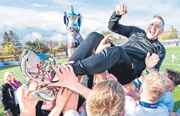  ?? Pictures: SNS Group. ?? Montrose players celebrate with manager Stewart Petrie after their League 2 title success last April.