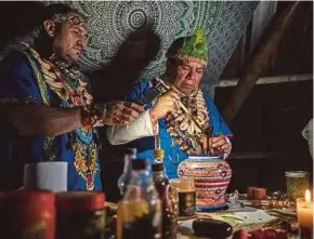  ?? AFP PIC ?? Colombian shaman Claudino Perez (right) serving ‘ayahuasca’ during a ceremony in La Mesa, Colombia on March 9.