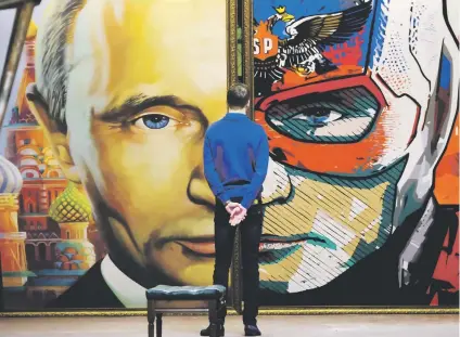  ?? Picture: AFP ?? SUPERMAN. A man looks at a painting depicting Russian President Vladimir Putin at the in Moscow last year. He is set to extend his long rule to 2024 in the presidenti­al election on Sunday. exhibition