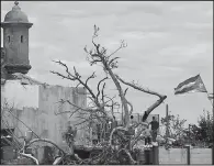  ?? AP/CARLOS GIUSTI ?? Residents in San Juan, Puerto Rico, take stock of the damage Monday, days after Hurricane Maria battered the island.