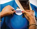  ?? AUDRA MELTON ?? A supporter in Valdosta hands out stickers Aug. 23 for Stacey Abrams, the first black woman to be a major-party nominee for governor in the United States.