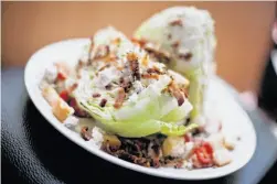  ??  ?? Above: The iceberg wedge served with house peppered bacon and Point Reyes blue cheese at Handles Gastropub on Main Street; right: Handles Gastropub also boasts a wide selection of beers on tap.