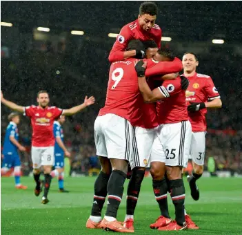  ?? AFP ?? Manchester United’s Antonio Valencia ( 25) celebrates scoring the opening goal with team mates in their EPL match against Stoke City at Old Trafford in Manchester on Monday. The hosts won 3- 0. —