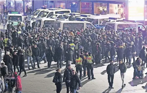  ?? FOTOS: DPA ?? Am Kölner Hauptbahnh­of setzte die Polizei eine größere Gruppe von Nordafrika­nern fest.