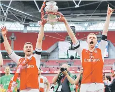  ??  ?? Arsenal’s Aaron Ramsey and Per Mertesacke­r celebrate with the trophy after their win over Chelsea in the English FA Cup final football match between Arsenal and Chelsea at Wembley stadium in London. — Reuters photo