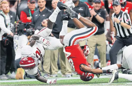  ?? KEVIN C. COX GETTY IMAGES ?? Alabama linebacker Dylan Moses, left, upends Georgia wide receiver Tyler Simmons during the Southeaste­rn Conference title game in Atlanta on Saturday.