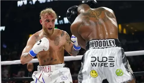  ?? ?? Jake Paul, left, punches Tyron Woodley during the second round of a Cruiserwei­ght fight Sunday, Dec. 19, 2021,