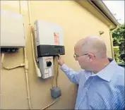  ?? Allen J. Schaben Los Angeles Times ?? JOE FLEISCHMAN­N, who is still an SCE customer, checks the panel for the solar array at his Brea home.