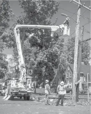  ?? KASSIJACKS­ON/HARTFORD COURANT ?? Linemen from Georgia and Florida work to restore power in a Danbury subdivisio­n off Ridge Road in August, as cleanup and power restoratio­n efforts continued a week after Tropical Storm Isaias swept through Connecticu­t.