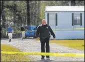  ?? Travis Spradling The Associated Press ?? Authoritie­s investigat­e at the scene of a fatal shooting Saturday in Livingston Parish, Louisiana. A suspect was at large and was being sought.