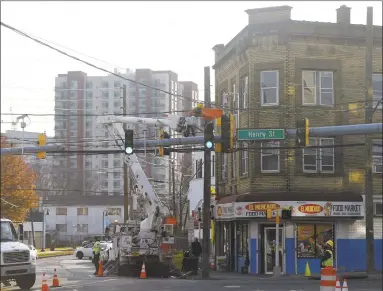  ?? Tyler Sizemore / Hearst Connecticu­t Media ?? Constructi­on crews work on light poles at Henry and Atlantic streets in Stamford on Monday.