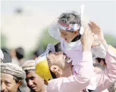  ?? — Reuters ?? Ansar Allah supporter holds his daughter during a funeral procession in Sanaa, Yemen, on Saturday.