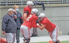  ?? KYLE ROBERTSON/ COLUMBUS DISPATCH ?? Ohio State offensive linemen Wyatt Davis (52) and Trey Leroux go through a drill during practice in Ohio Stadium on Oct. 3.