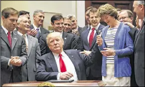  ?? AP ?? President Donald Trump gives the pen he used to sign an executive order to Sen. Lisa Murkowski, R-Alaska, on Friday.