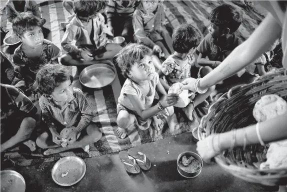  ?? SAURABH DAS/The Associated Press ?? Children are served flatbreads, part of a meal that includes a scoop of boiled potato curry at a government-run program serving lunch in Madkheda, Madhya Pradesh state, India.