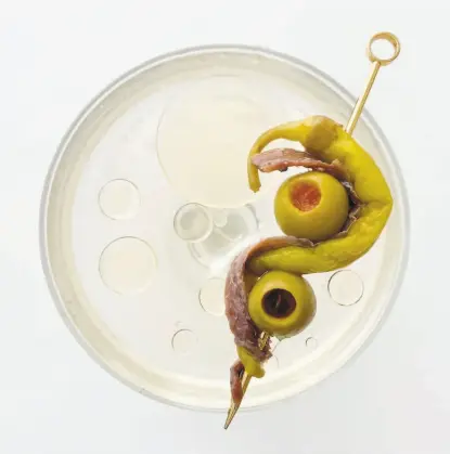  ?? Omar Mamoon ?? A Gildatini is garnished with a skewer of Cantabrian anchovy, pickled piparra peppers and manzanilla olive.