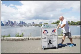  ?? MARY SCHWALM / ASSOCIATED PRESS FILE (2021) ?? Paul Veneto pushes a beverage cart Aug. 21, 2021, along the Boston Harbor. Veneto, a former f light attendant who lost several colleagues when United Flight 175 was flown into the World Trade Center on Sept. 11, 2001, annually honors his friends by pushing the beverage cart to sites directly affected on 9/11. This year’s journey took him to Shanksvill­e, Pa.