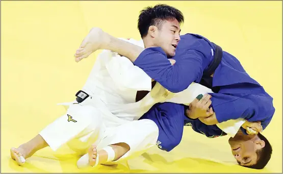  ?? (AFP) ?? Gold medalist Japan’s Soichi Hashimoto (white) competes with Azerbaian’s Rustam Orujov (blue) during their final in the menís -73kg category at the World Judo Championsh­ips in Budapest
on Aug 30.