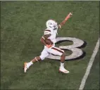  ?? Andy Lyons / TNS ?? Jaylan Knighton of the Miami Hurricanes runs for a touchdown in the third quarter against Louisville at Cardinal Stadium in Louisville, Ky., on Saturday. Miami won 47-34, and moved up five spots to No. 12 in The Associated Press Top 25 poll.