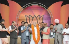  ??  ?? NEW DELHI: Gujarat state Chief Minister and the Bharatiya Janata Party’s (BJP) prime ministeria­l candidate, Narendra Modi (C) wears a garland as he greets supporters with other senior leaders during an election rally in New Delhi yesterday. Chief...