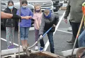  ??  ?? Poplar Avenue Elementary School third grade student Bryant Lopez shovels dirt while helping plant a tree Friday.