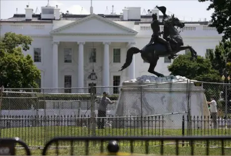  ?? Jacquelyn Martin/Associated Press ?? The base of the statue of former President Andrew Jackson is power-washed Wednesday inside a newly closed Lafayette Park in Washington, which has been the site of protests against racism and police brutality following the death of George Floyd, a Black man who was killed May 25 while in police custody in Minneapoli­s.