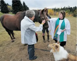  ?? JOHN LUCAS/ EDMONTON JOURNAL ?? Susan Oliver of St. George’s Anglican Church blesses Jeanette Buckingham’s horse last fall. This year’s blessing takes place Sunday at 2 p.m.