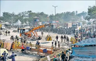  ?? ANI ?? Police personnel erect barricades at Singhu border on Wednesday.
