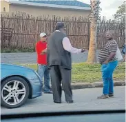  ??  ?? ALSO THERE: United Front provincial executive committee member Lungile Mxube, wearing the red T-shirt, left, with Nelson Mandela Bay human settlement­s acting executive director Mvuleni Mapu, in black, outside the Bay venue