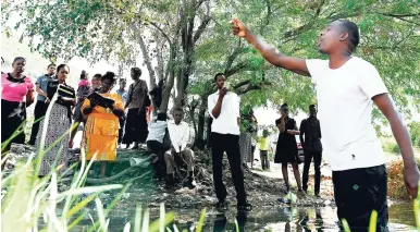  ?? FILE ?? Pastor Steven Hayles of the newly formed Church of Pentecost Jamaica preaches in knee-deep water to the congregati­on after a baptismal ceremony on January 14 at a stream that runs from the Rockfort Mineral Spa in east Kingston.