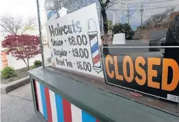 ?? TONY DEJAK/AP ?? A barbershop in Cleveland sits closed May 6 amid the coronaviru­s pandemic.