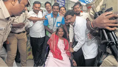  ??  ?? Kasthuri Munirathin­am moves toward an ambulance in a wheelchair after her arrival at the airport in Chennai last November after her ordeal in Saudi Arabia.