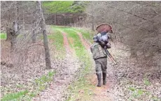  ?? PAUL A. SMITH / MILWAUKEE JOURNAL SENTINEL ?? Tim Eisele of Madison carries a turkey he shot April 19 in Crawford County.