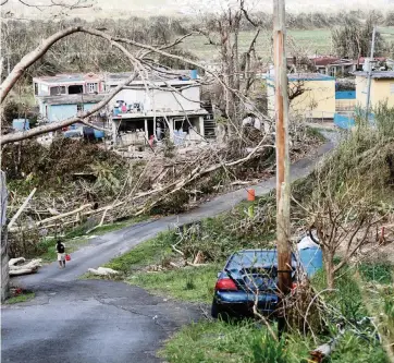 ?? GERALD HERBERT AP ?? Jonathan Aponte returns home to Yacuboa, Puerto Rico, on Sept. 26, 2017, after the devastatio­n caused by Hurricane Maria. President Donald Trump said Friday: ‘I’m the best thing that ever happened to Puerto Rico. Nobody even close.‘